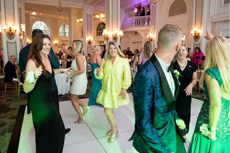 A group of people in formal attire dance and socialize on a white dance floor during SITE Southeast&rsquo;s Southern Supper Prom Night.